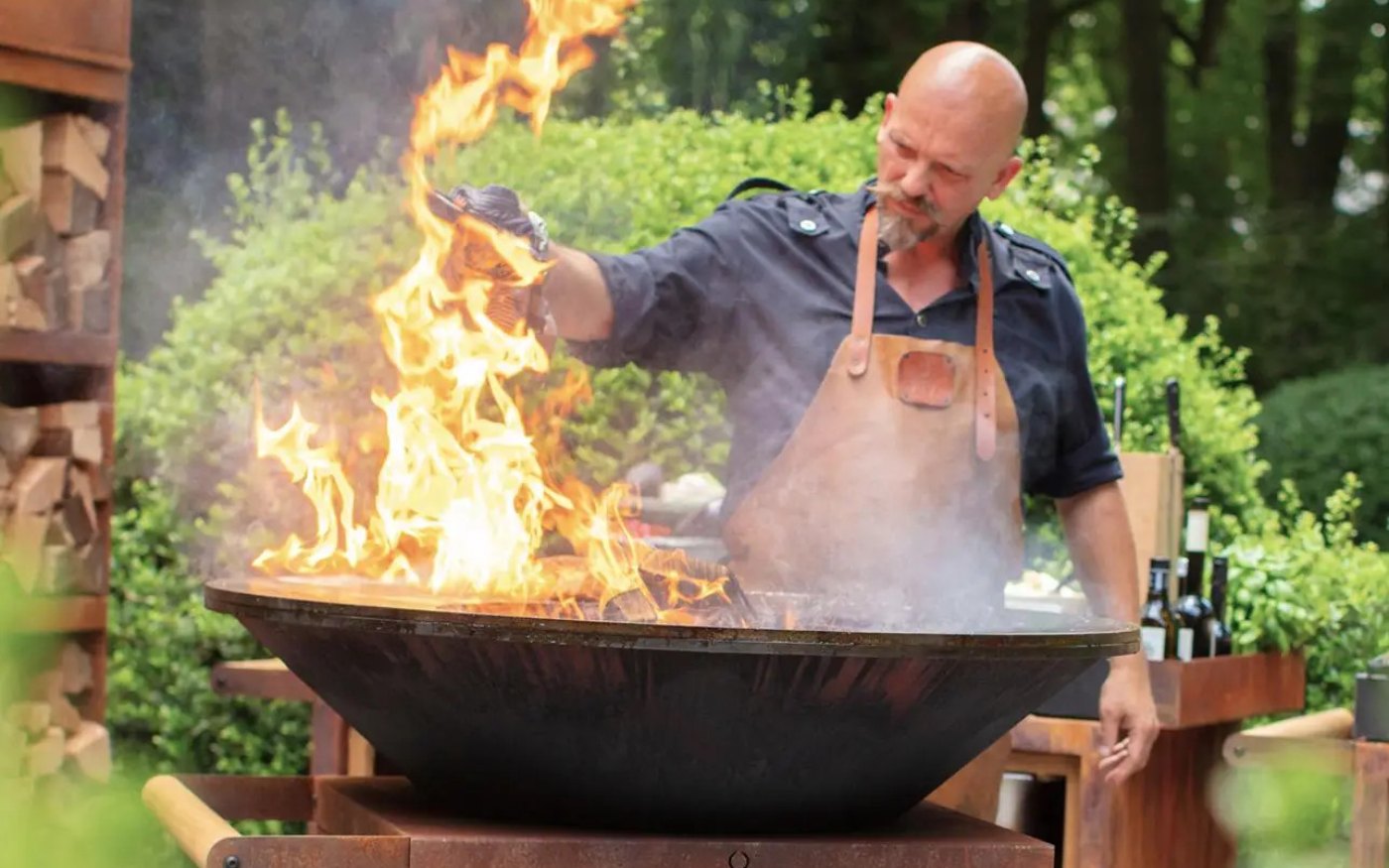 Chef cuisinant sur un brasero-plancha Ofyr